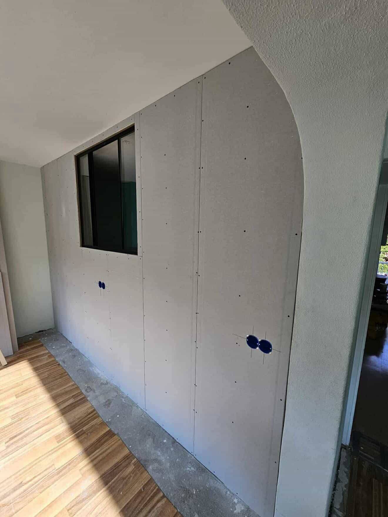 Maatwerk gebogen gipswand — zachte boog als overgang tussen twee ruimtes