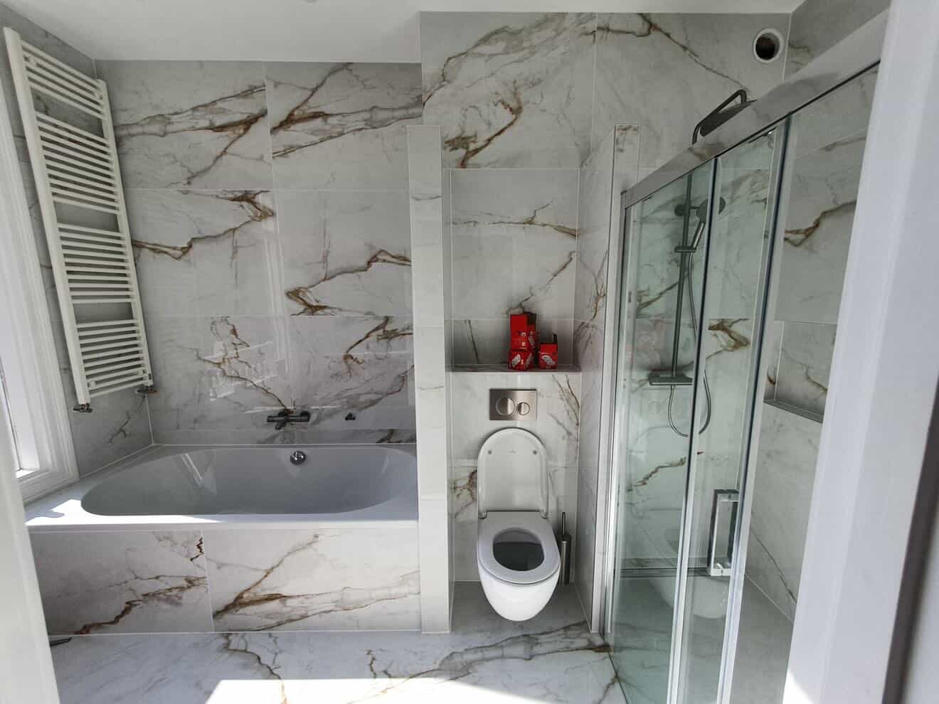 Calacatta marmer badkamer met ligbad, zwevend toilet en inloopdouche