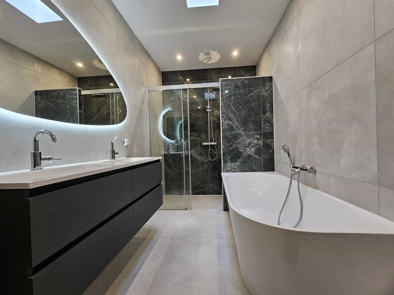 Grijze marmer badkamer met zwarte zwevende vanity en vrijstaand bad